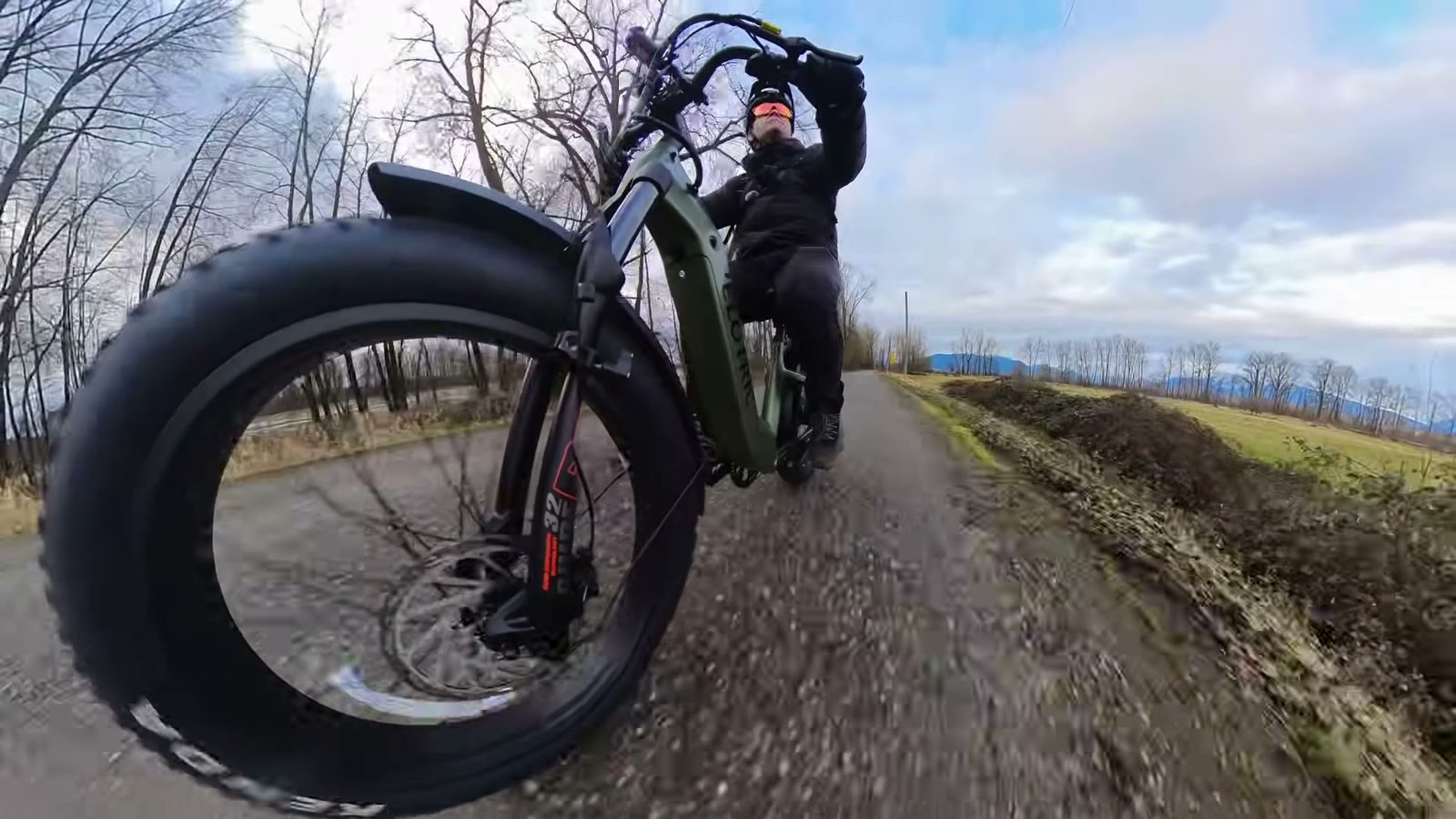 Low angle of the Velotric Nomad 2 fat front tire rolling down a gravel path