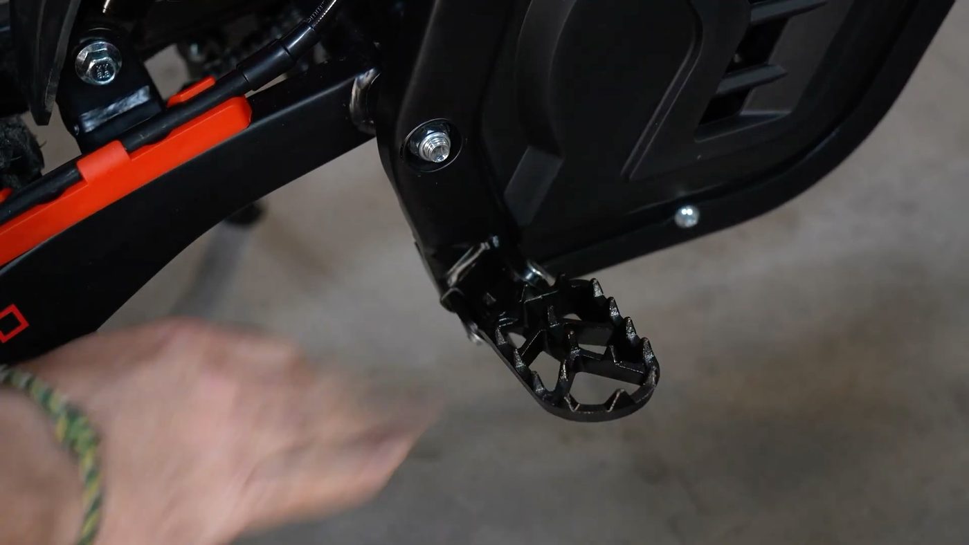 Spring-loaded foot peg with spikes
